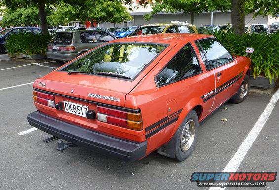 Orange Toyota Corolla parked in a lot, rear view. License plate OK8517
