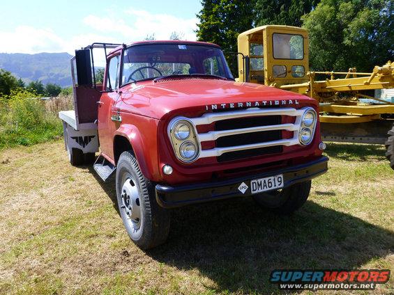 Red International truck front view with white grille and license plate DMA619