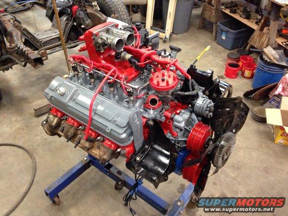 Engine on a blue stand, painted red and gray with black components