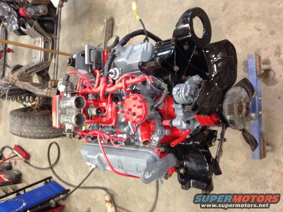 Engine with red and gray paint, black accents, and dual carburetors