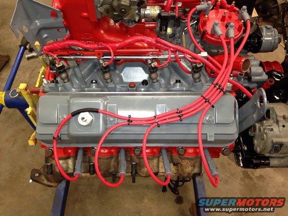 Engine block painted red and gray, with red spark plug wires and fuel injectors