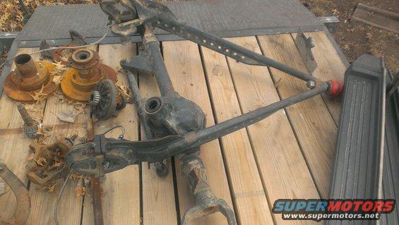 Front axle and suspension parts on wooden planks
