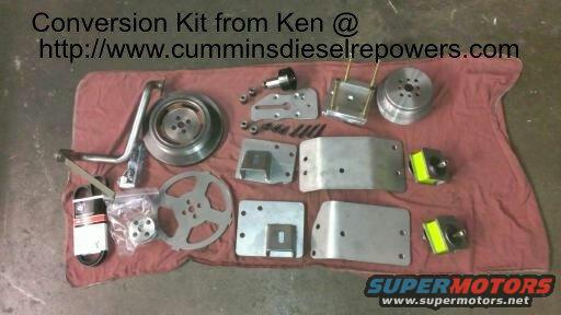 Metal brackets, pulleys, and a belt laid out on a red cloth