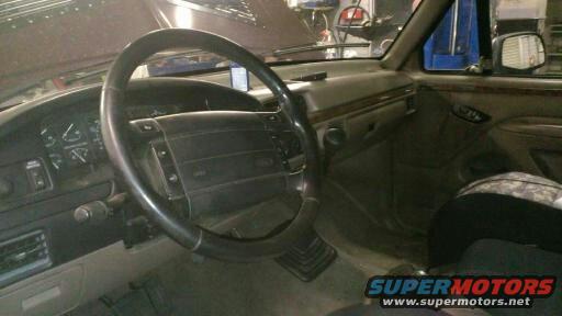 Interior shot of a vehicle, showing the steering wheel, dashboard, and passenger seat