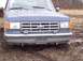 1987 Ford Bronco - This 1987 Ford Bronco is stuck in the mud, showing its front grille and headlights.