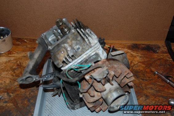 Disassembled small engine, possibly from a lawnmower or ATV, sitting in a gray tray