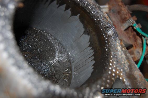 Close-up of an engine cylinder showing significant scoring marks and oil residue