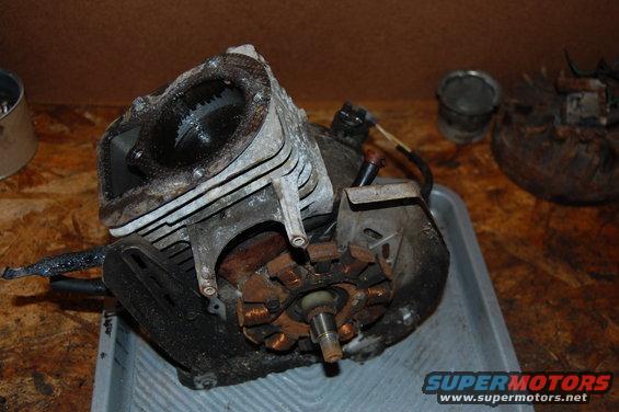 Engine block with piston visible, starter motor components, and wiring. It's dirty and appears to be disassembled