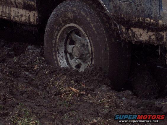 tire of a vehicle sunk deep in mud