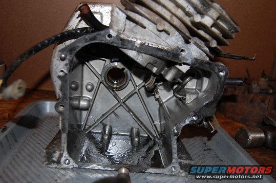 Engine block disassembled, showing internal parts and oil residue. Supermotors.net logo visible