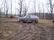 1987 Ford Bronco - This 1987 Ford Bronco is deeply stuck in a muddy field, with only its wheels and lower body visible above the mire.