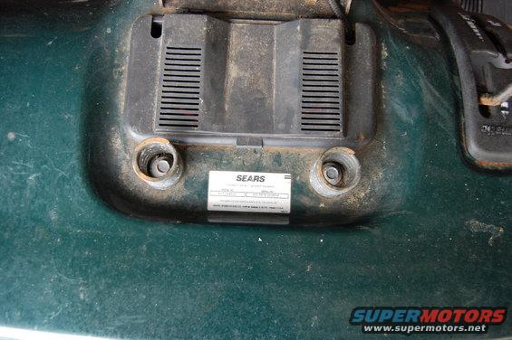 Green lawn mower deck with a Sears identification label and two bolt holes