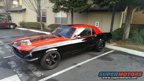 Black and orange 1967 Ford Mustang parked in a lot