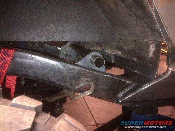 Jeep frame with red strap and metal bracket attached to a tube