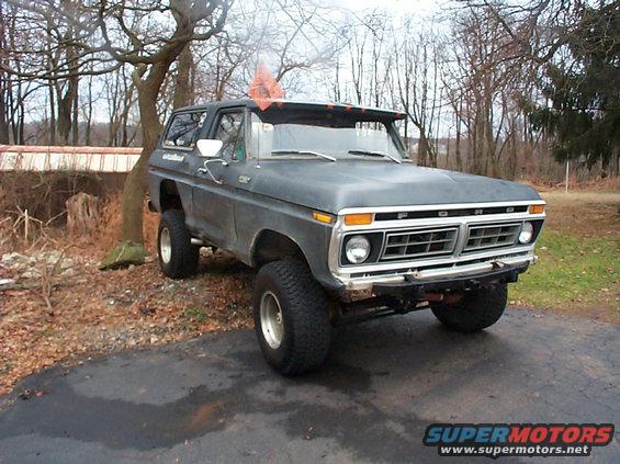 Dark gray 1978 Ford Bronco with lifted suspension and aftermarket bumper parked on asphalt