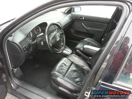 Black leather interior of a car, showing dashboard, steering wheel with Audi logo, and front seats