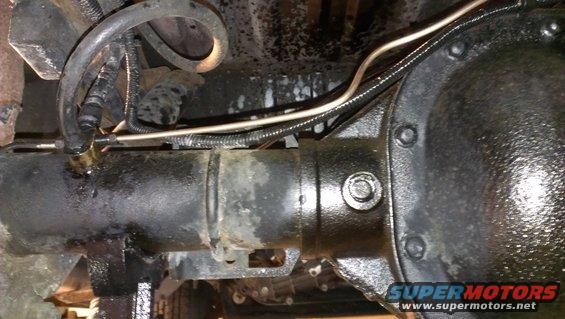 Rear axle assembly with brake lines and hoses, showing some fluid leakage