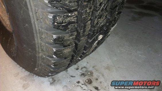 Close-up of a worn tire with visible damage on the sidewall