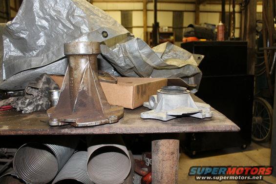 Two metal transfer case components on a workbench