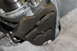 1995 Ford Bronco - Close-up of a vehicle's transfer case linkage mechanism, showing intricate metal components and guides.