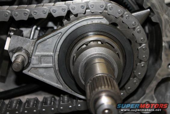 Close-up of transfer case chain and gears with a SuperMotors.net watermark