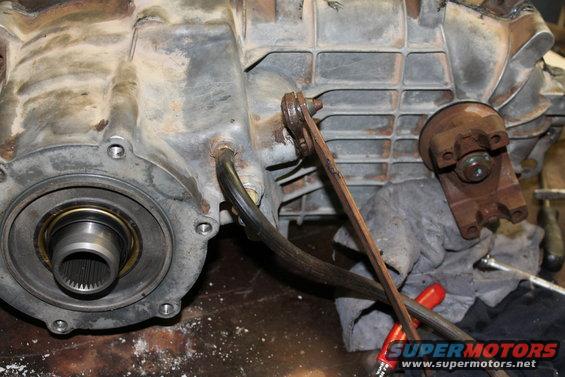 Close-up of a transfer case assembly with a wrench on a linkage