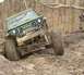 1992 Ford Bronco - A green Suzuki navigates a challenging off-road course in a wooded area.