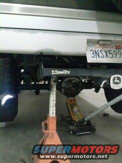 rear axle, hitch, and jack stands under a vehicle