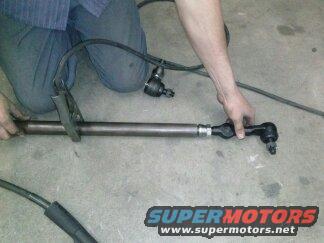 Person holding a tie rod assembly with some cables attached