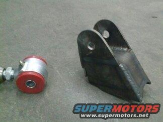 Suspension part with red bushings and metal bracket on concrete