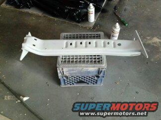 White automotive part on a crate, with spray cans nearby