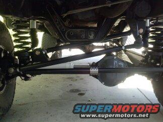 Undercarriage view of front solid axle, suspension components, and steering linkage