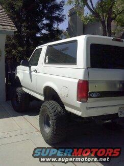 White SUV with large tires parked on a driveway