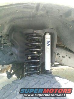Close-up of a coil spring and shock absorber assembly, likely from a truck or SUV
