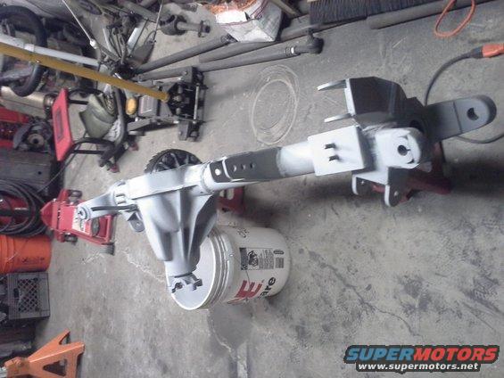 Rear axle assembly painted gray, resting on a bucket and jack stands