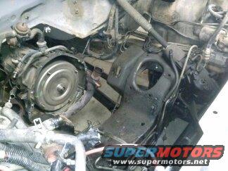 Engine bay with transmission and hoses. SuperMotors.net logo visible