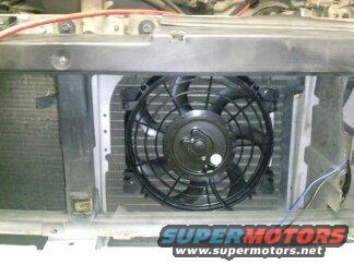 Electric fan mounted on a radiator with wiring. SuperMotors.net logo visible