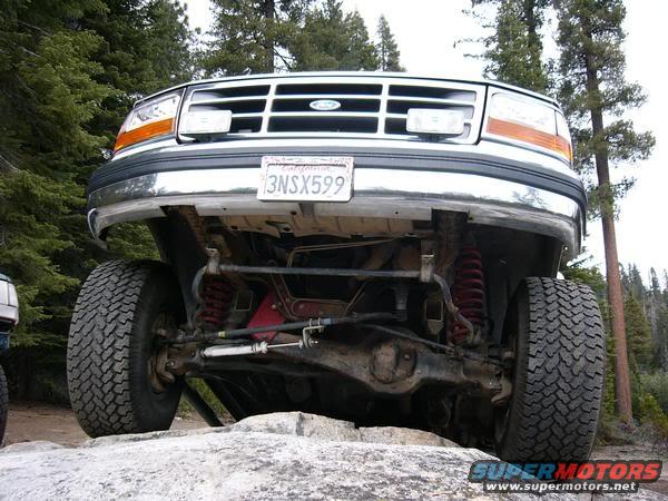 1995 Ford Bronco front end with California license plate 3NSX599, showing suspension and tires on rocks