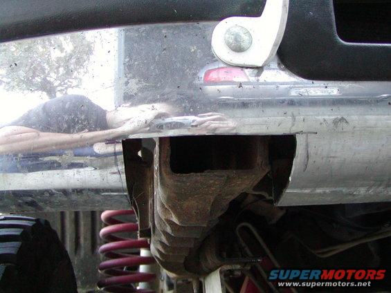 Undercarriage view of a vehicle, showing red coil springs and a chrome bumper