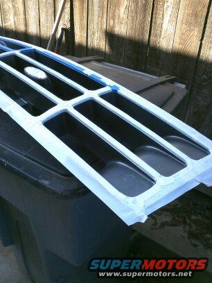 1995 Ford Bronco grille, taped for painting, with oval emblem visible