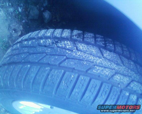 Close-up of a tire tread with white residue. Supermotors.net logo visible