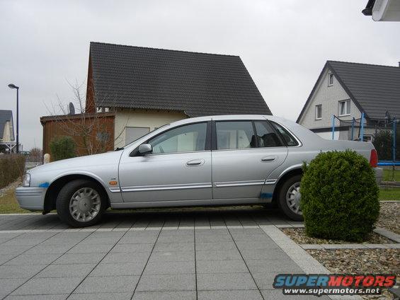 1999 Ford Fairlane sedan, side view, parked on paved driveway