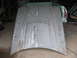 1972 Ford Ranchero - Unpainted car hood with a central raised scoop sits in a garage.