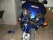 2006 Honda Reflex - A blue motorcycle sits with its front fairing heavily damaged, revealing internal components. Loose blue body panels are scattered on the f…