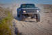 1996 Ford Bronco - This off-road truck is navigating a dusty desert terrain.