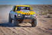 1996 Ford Bronco - This yellow pickup truck, modified for off-road racing, kicks up dust as it speeds along a desert track.