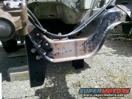Close-up of a rusty vehicle frame section with a steering component attached