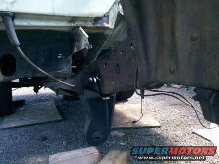 close-up of vehicle frame and suspension parts, possibly under repair