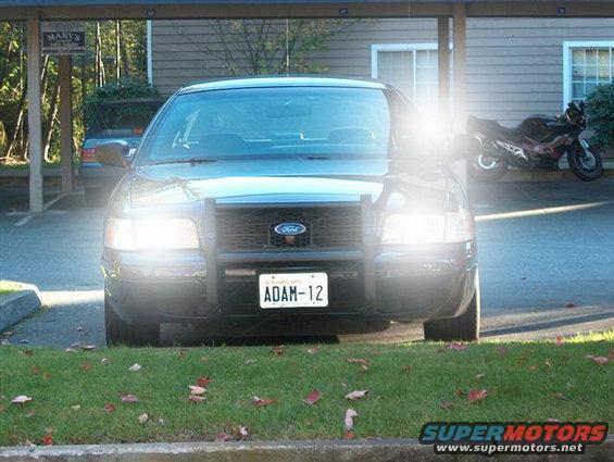 Black 2001 Ford Crown Victoria police car with a push bumper, facing forward