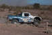 1996 Ford Bronco - A custom-built off-road truck competes in a desert race, dust billowing behind it.